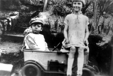 Sid aged 3 or 4 in his peddle car and his sister Eve, aged 5 or 6.