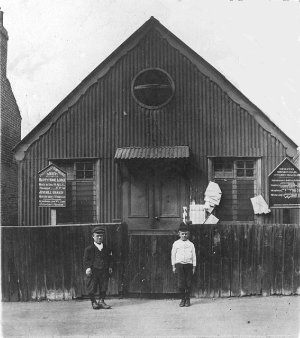 Church Hall in Sutcliffe Road just off
                            the Slade. Alf Hall (the dwarf man) worked
                            at Mackintoshes as maintenance engineer and
                            because he was smaller than most was able to
                            get into very tight places. Mackintoshes was
                            at the bottom of Kings Highway. The boy is
                            Fred Smith. The photo is c. 1918. Photo:
                            John Miles