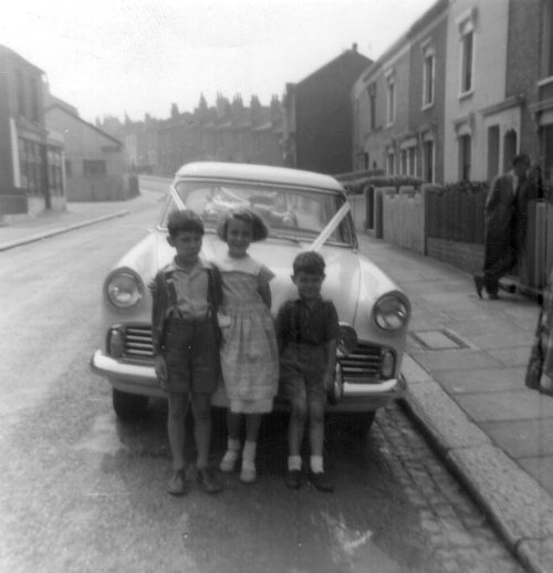 Wynne Handley (nee Winifred English) with 2 cousins and uncle Jim's taxi car Maxey Road late 1950's